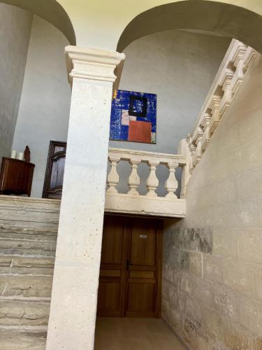 a staircase in a building with a wooden door at Chambres d'hôtes au Château de Gandillac in Saint-Martial-Viveyrol