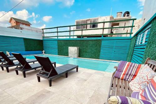 a swimming pool with lounge chairs and a building at Depto Excelente ubicación Vista parcial Mar in Boca del Río