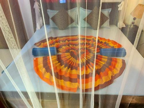 a display case with an orange and yellow blanket at Deshan Homestay & Restaurant in Tangalle