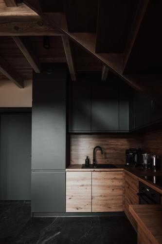 a kitchen with wooden cabinets and a sink at Ptasia ferajna - domki całoroczne w Dolinie Baryczy in Milicz