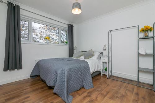 a white bedroom with a bed and two windows at Parkview Guesthouse in Chesfield