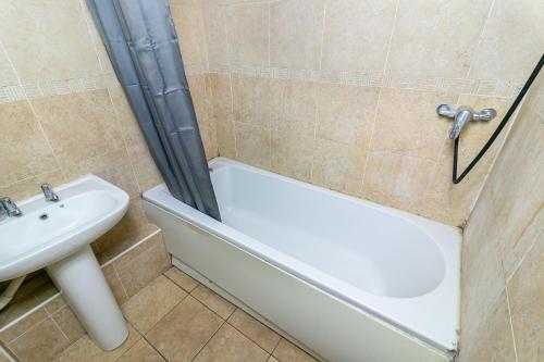 a bathroom with a sink and a tub and a toilet at Parkview Guesthouse in Chesfield