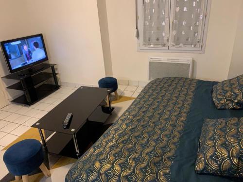 une chambre avec un lit, une table et une télévision dans l'établissement Studio centre ville Angers, à Angers