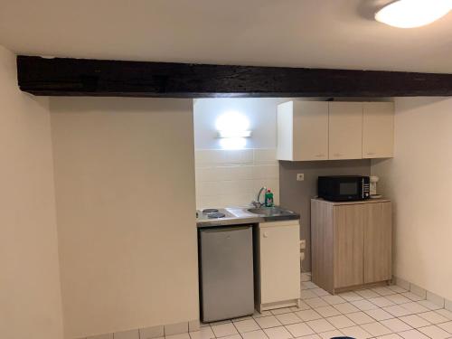 une petite cuisine avec un évier et un micro-ondes dans l'établissement Studio centre ville Angers, à Angers