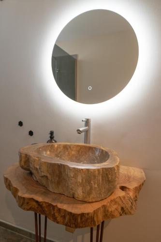 a bathroom with a wooden sink and a mirror at San Domenico Suite Cavallino in Cavallino di Lecce