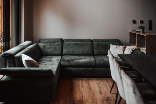 a living room with a green couch and a table at Ptasia ferajna - domki całoroczne w Dolinie Baryczy in Milicz