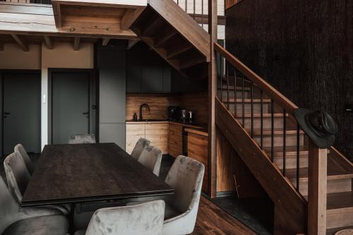 a dining room with a wooden table and a staircase at Ptasia ferajna - domki całoroczne w Dolinie Baryczy in Milicz