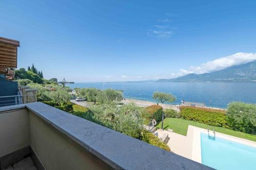 a view of the water from a house with a swimming pool at ApartmentsGarda - Il Tesoro del Lago in Torri del Benaco