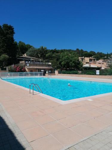une grande piscine avec de l'eau bleue dans l'établissement Appartement rdc terrasse vue panoramique mer, à La Croix-Valmer