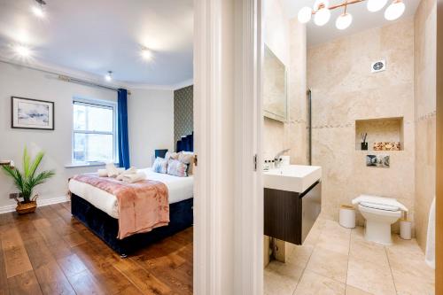 a bedroom with a bed and a sink and a toilet at Welcome London Leicester Square in London