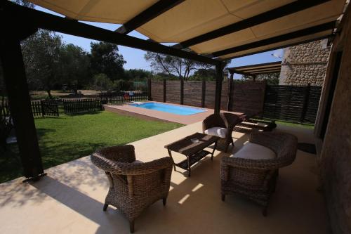 a patio with chairs and a table and a pool at 5 Stars Villas in Svoronata