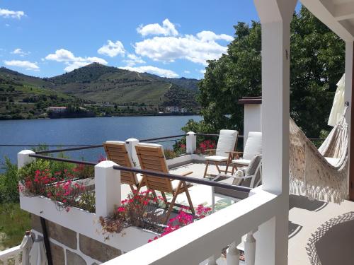 a balcony with chairs and a view of a lake at Casa dos Vinhais Douro Valley in Coleja