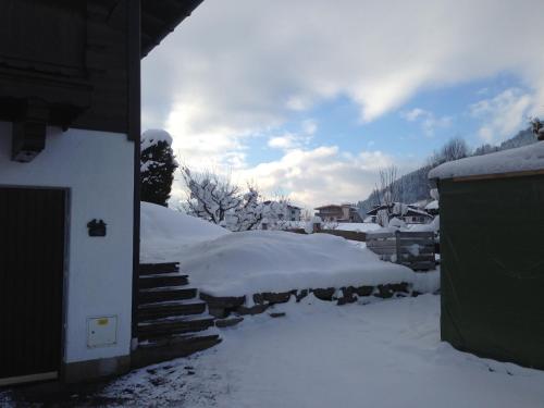a snow covered yard with stairs and a house at Appartements Strasser Angelika in Westendorf