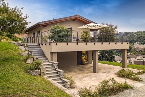 a house with a staircase and an umbrella at Appartamenti Caffè Maya in Maslianico