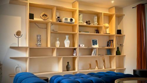a living room with shelves filled with vases at Domaine Le Petit Moulin in Lachy
