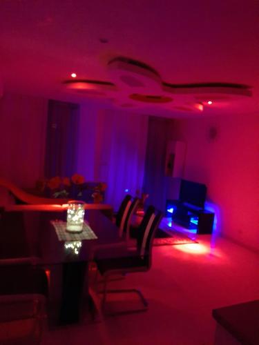 a living room with a table and purple lights at Joyce City in Knutange