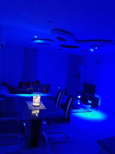 a blue room with a table with chairs and a laptop at Joyce City in Knutange