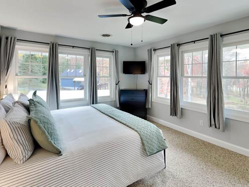 a bedroom with a bed with a ceiling fan and windows at Starlit Memories in Swanton