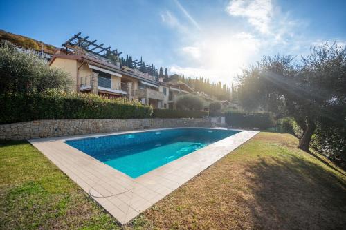a swimming pool in a yard next to a house at ApartmentsGarda - Il Tesoro del Lago in Torri del Benaco