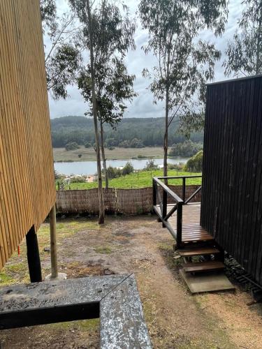 a wooden walkway leading to a deck with a view of a lake at Cabaña de campo in Vichuquén