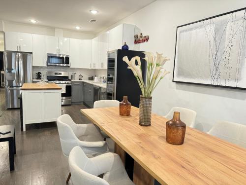a kitchen with a wooden table and white chairs at Stunning NYC rooftop views minutes away from NYC 2 bedroom 2 bath in Jersey City