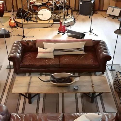a brown leather couch sitting on top of a coffee table at Homebase by Revier in Saas-Fee