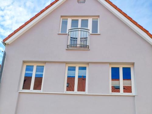a white house with windows and the ocean at Business-Apartments im SCHUSTER-ACHT in Wolgast