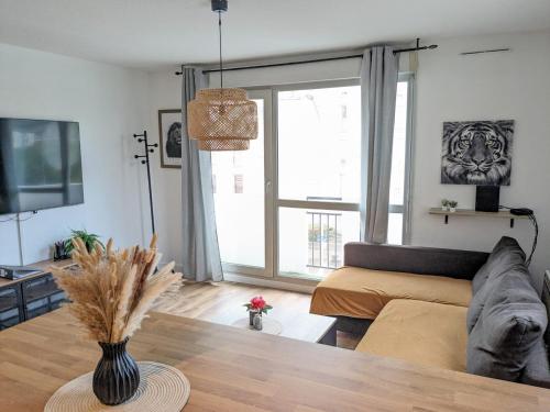 a living room with a couch and a table at Le Clairvaux - Proche centre avec 1 place en parking souterrain in Dijon