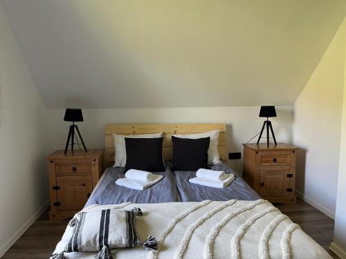 a bedroom with a large bed with two night stands at Domki nad rzeką- Smerekowiec in Smerekowiec
