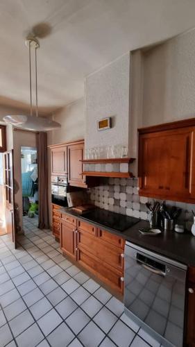 une cuisine avec des placards en bois et des comptoirs noirs dans l'établissement L'Authentique et Spacieux - Vieille Ville, à Annecy