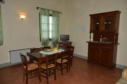 a dining room with a table and chairs and a television at Agriturismo Musignano in Cerreto Guidi