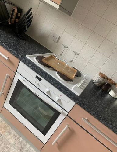 a kitchen with a stove with a cutting board on it at Southampton Central Pad in Southampton