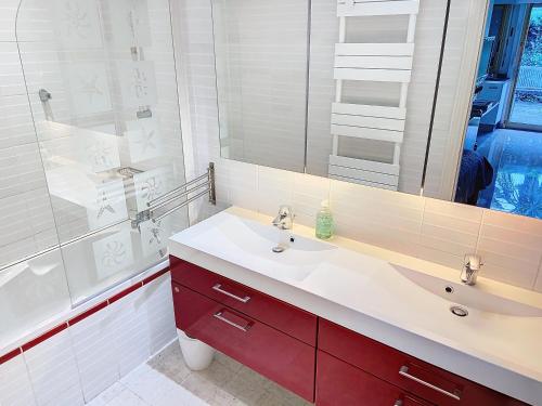 La salle de bains est pourvue d'un lavabo rouge et d'une douche. dans l'établissement A 2 pas des plages piscine 183L STENJ, à Cannes