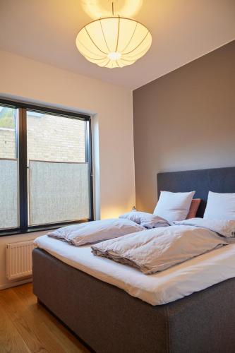 a bedroom with a large bed with a large window at Amaliegade 10 B in Aarhus