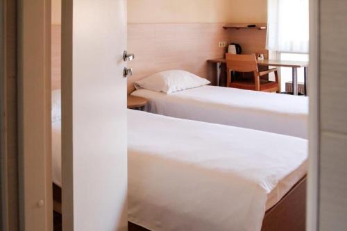 two beds in a small room with a table and a table at LUNA Marijampole in Marijampolė