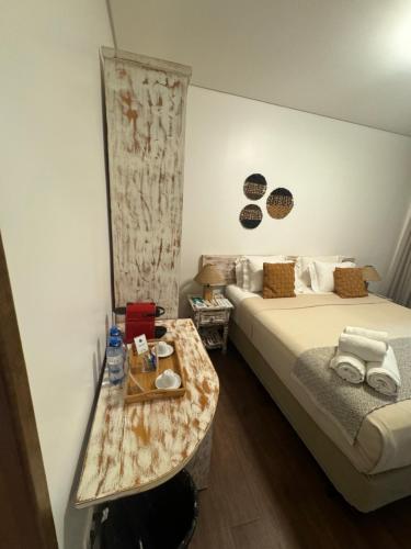 a hotel room with a bed and a table at Pousada da Germana in Fernando de Noronha