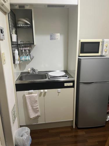 a small kitchen with a sink and a microwave at ToyamaHouse2-202 in Tokyo