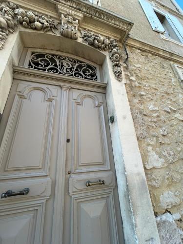 une porte blanche sur un bâtiment avec une fenêtre dans l'établissement Appartement spacieux en Provence, à Châteaurenard