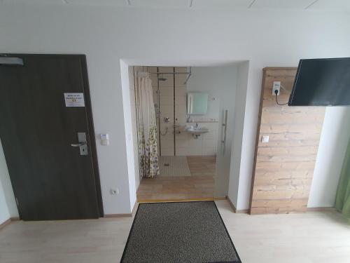 a room with a door and a bathroom at Hotel Garni Pegnitz # Schlabecks Fränkischer Hof in Pegnitz