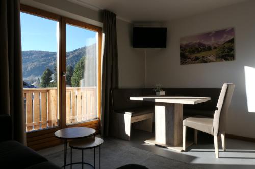 a room with a table and a balcony with a view at Haus Katris in Mauterndorf
