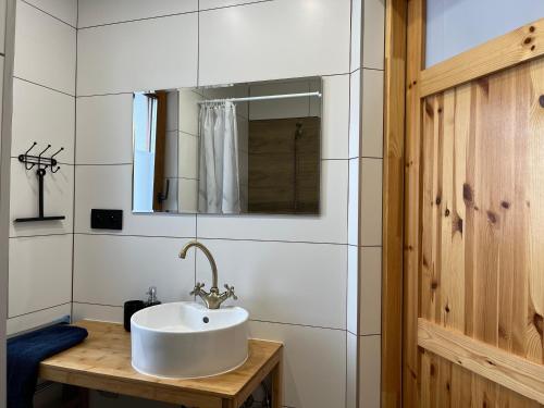 a white bathroom with a sink and a mirror at Domki nad rzeką- Smerekowiec in Smerekowiec