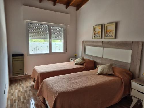 een slaapkamer met twee bedden en een raam bij Departamento Las Calandrias in Cipolletti