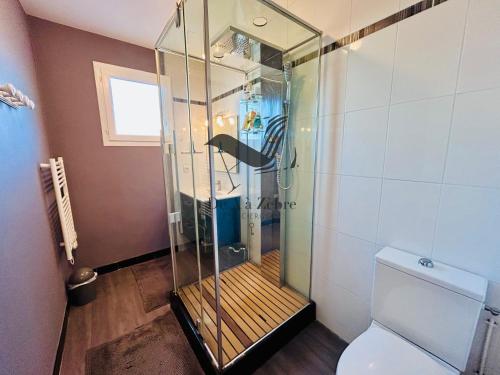 La salle de bains est pourvue d'une douche en verre avec un poisson. dans l'établissement Villa Georgette - Proche des plages, à La Tremblade