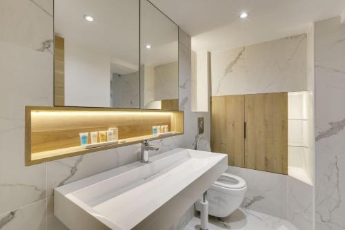 une salle de bain blanche avec un lavabo et des toilettes dans l'établissement 180 Suite Steph - Superbe Appartement à Paris, à Paris