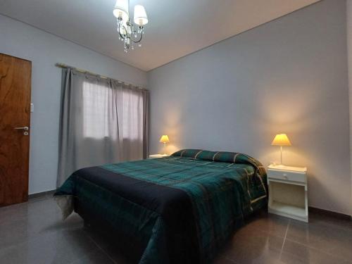 een slaapkamer met een groen bed en een raam bij Departamentos Corazón in San Rafael