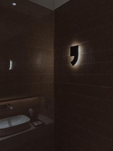 a dark bathroom with a toilet and a sink at SOKO' Stay at Kedungu in Tanah Lot