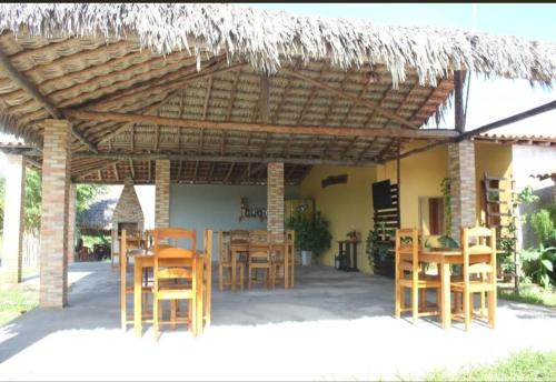 pérgola de madera con sillas y mesas debajo en Flor da Mata- Ilha das Canárias, en Araioses