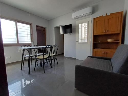 een woonkamer met een tafel, stoelen en een bank bij Departamentos Corazón in San Rafael