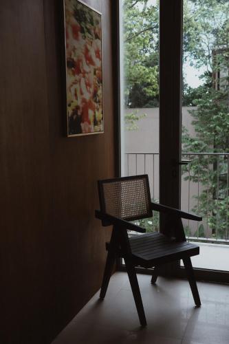 a chair sitting in front of a window at SOKO' Stay at Kedungu in Tanah Lot