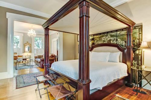 a bedroom with a canopy bed and a living room at 17 E Jones Street Parlor in Savannah